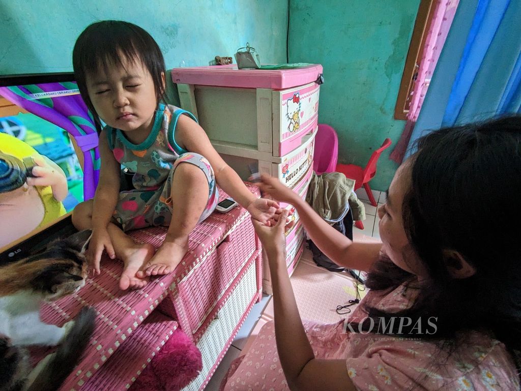 Ayu (30) mengambil sampel darah dari ujung jari anak bungsunya, Bianca (2) untuk diperiksa kadar gula darahnya, saat ditemui di rumahnya, Cibinong, Kabupaten Bogor, Senin (3/4/2023) siang. Bianca mendapat diagnosa diabetes melitus tipe 1 sekitar 5 bulan lalu, di akhir 2022.