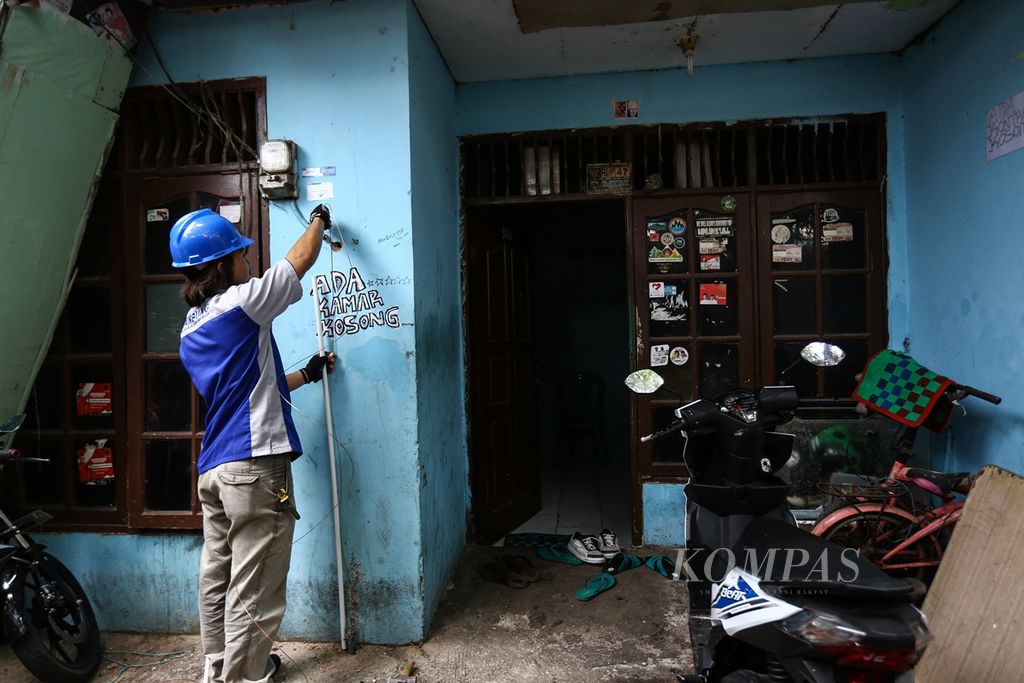 Petugas PLN memasang kawat pentanahan atau sistem <i>grounding </i>dari kWh meteran listrik rumah warga di permukiman padat di Kelurahan Jembatan Besi, Kecamatan Tambora, Jakarta Barat, akhir Agustus 2019.