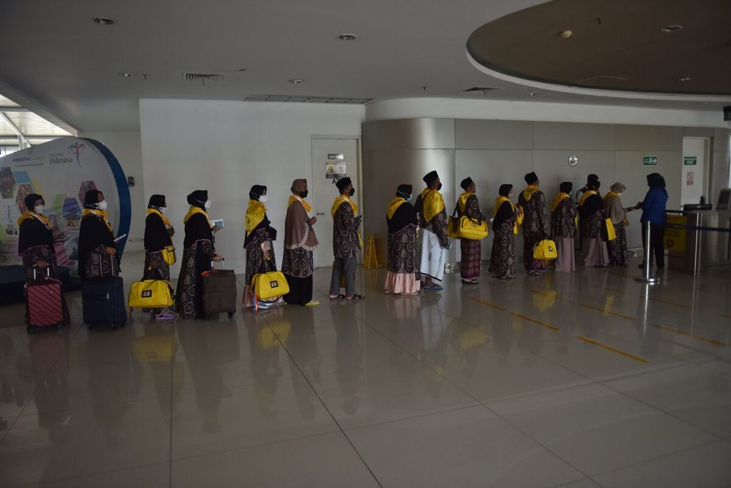 Jemaah umrah antre memeriksakan barang bawaan serta tiket di Terminal 2 Bandara Internasional Juanda Surabaya, Kabupaten Sidoarjo, Jawa Timur, Senin (14/3/2022).