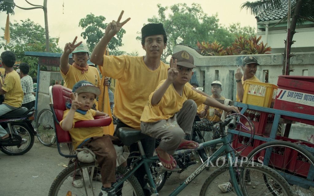 Memasuki putaran kedua, massa dengan atribut Golkar warna kuning memanfaatkan segala kendaraan berkeliling di sejumlah kawasan Jakarta seperti terlihat salah satu simpatisan yang mengajak anaknya bersepeda, Rabu (30/4/1997). 