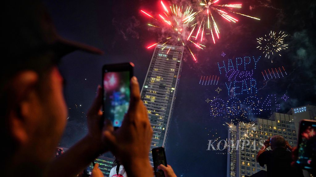 Formasi 500 <i>drone </i>membentuk tulisan Happy New Year 2024 di kawasan Bundaran Hotel Indonesia, Jakarta, saat tepat perayaan Tahun Baru 2024, Senin (1/1/2024).