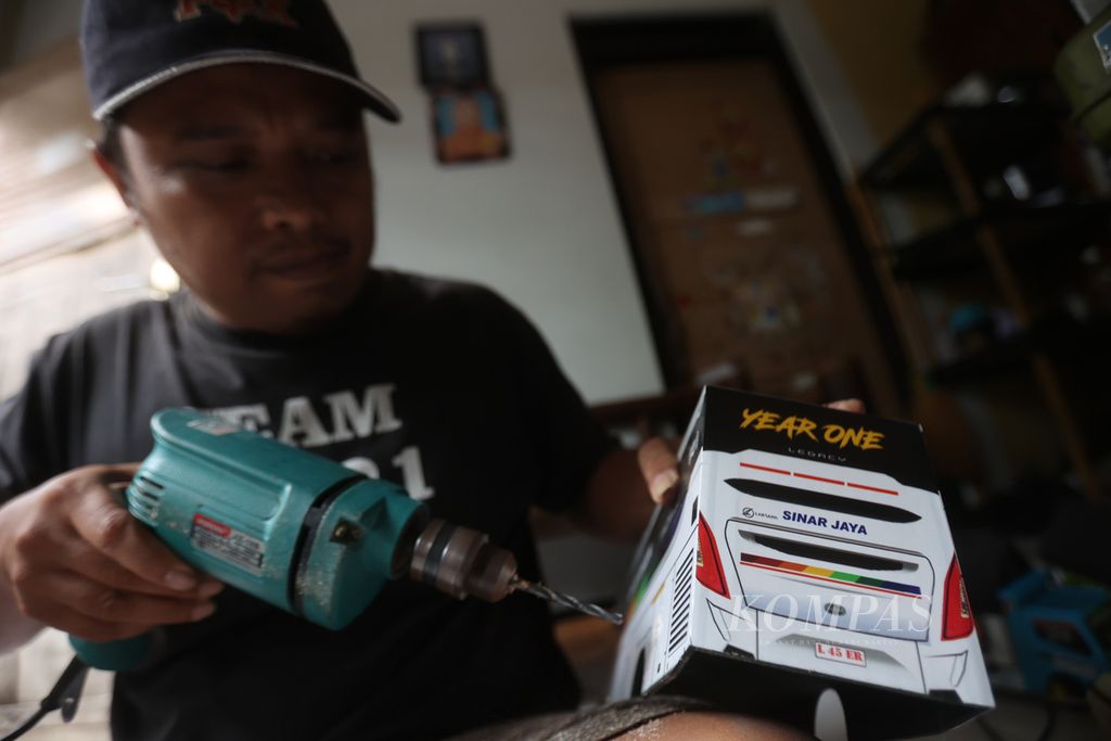 Wachid Isrodin (46) menggarap mainan miniatur truk dan bus di tempat usaha kerajinan Laser, Kelurahan Jurangombo Selatan, Magelang Selatan, Kota Magelang, Jawa Tengah, Selasa (18/10/2022). 