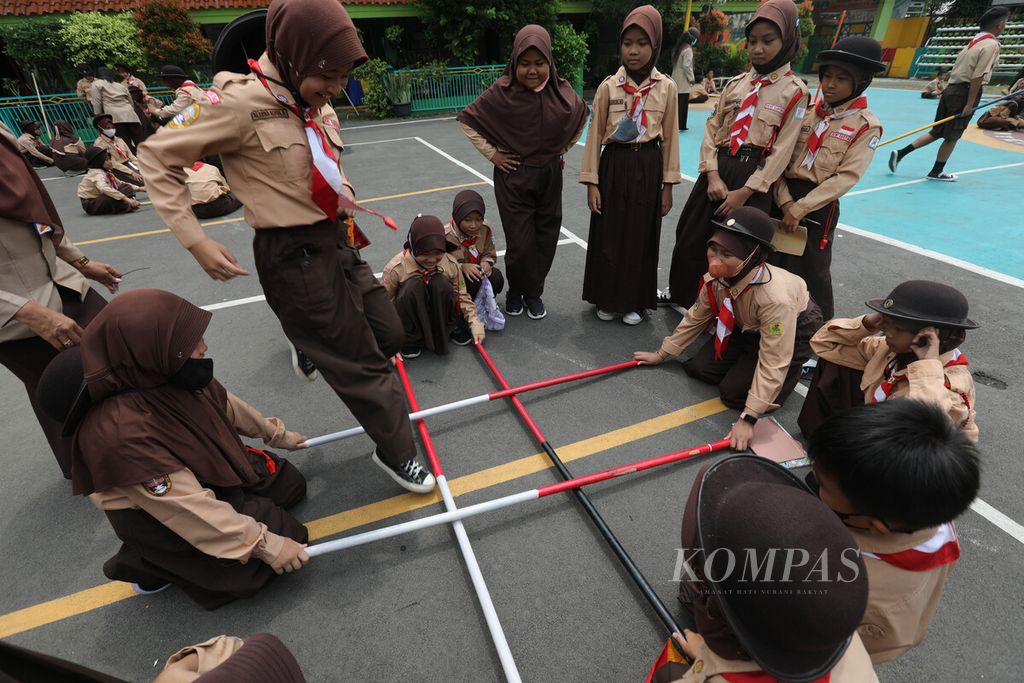Siswa SD Negeri 07 Ujung Menteng, Jakarta Timur, bermain lompat tongkat saat mengikuti sesi ekstrakurikuler Pramuka di halaman sekolah mereka, Rabu (4/1/2023). 