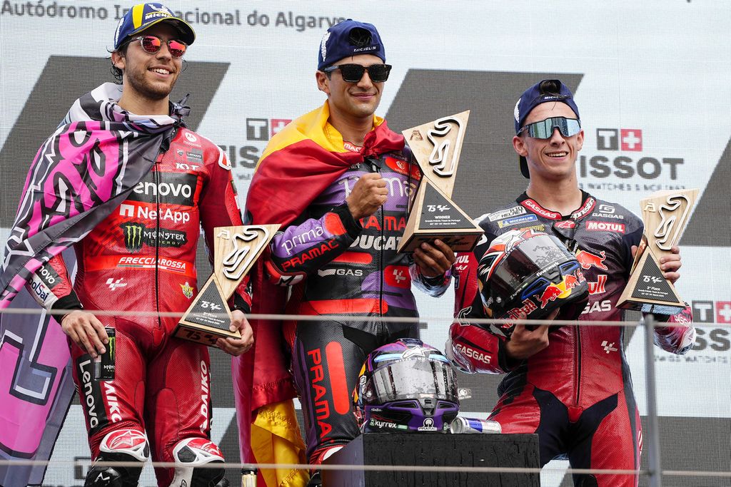 Ducati Pramac racer Jorge Martin (center) poses on the podium with Ducati Lenovo racer Enea Bastianini (left) in second place and GasGas Tech3 racer Pedro Acosta in third place at the MotoGP Grand Prix of Portugal at the Algarve International Circuit in Portimao, Portugal on Sunday (24/3/2024).