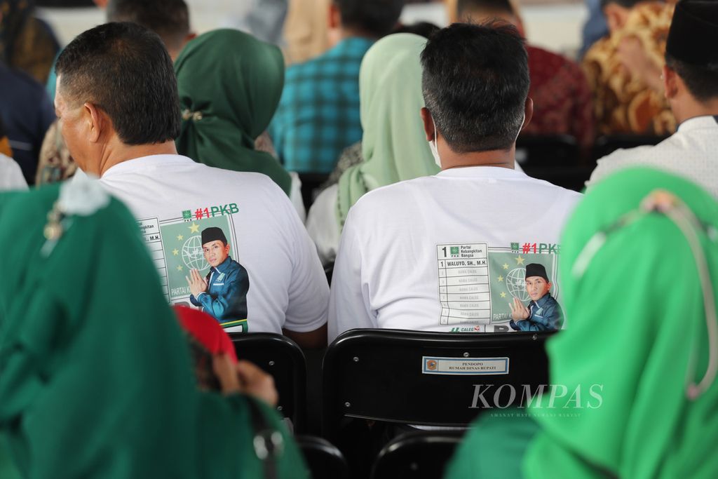 Simpatisan Partai Kebangkitan Bangsa mengenakan baju salah satu bakal caleg saat mengikuti kirab KPU di Rumah Dinas Bupati Karanganyar, Jawa Tengah, Selasa (26/9/2023).  
