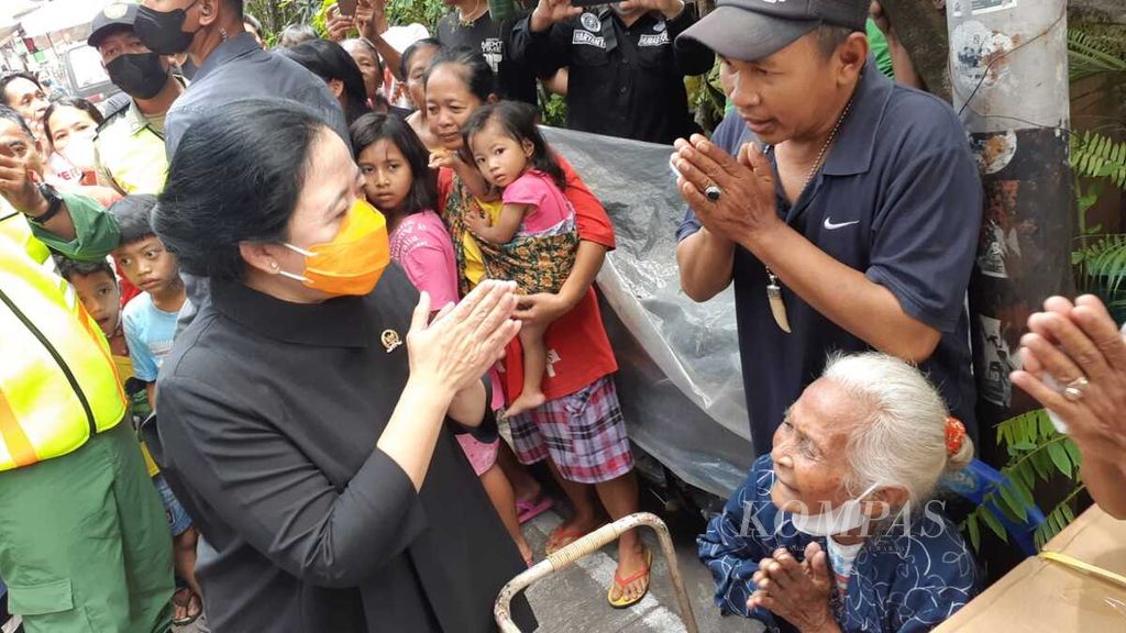 Ketua DPR Puan Maharani (kiri) menyapa warga yang diberi bantuan di Kelurahan Kratonan, Kecamatan Serengan, Kota Surakarta, Jawa Tengah, Minggu (2/10/2022).