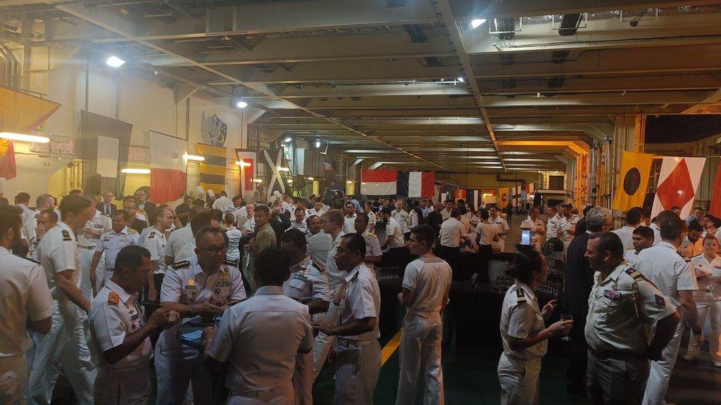 Tuan rumah dan tamu yang berpesta di geladak kapal perang <i>landing helicopter dock</i> (LHD) Dixmude yang sedang sandar di Tanjung Priok, Jakarta, Selasa (28/3/2023). <i>Cocktail party</i> sudah menjadi tradisi turun-temurun seluruh angkatan laut di dunia.