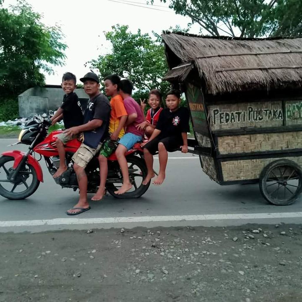 Robianto bersama anak-anak membonceng sepeda motor Pedati Pustaka.