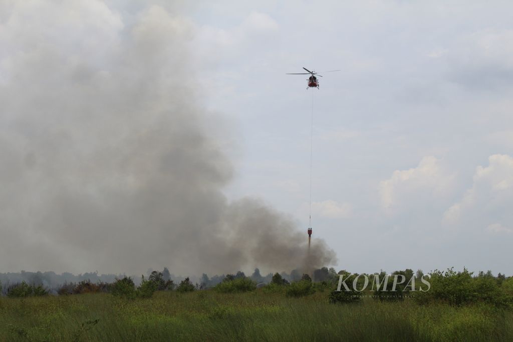 Helikopter<i> water bombing</i> milik BNPB membantu upaya pemadaman kebakaran hutan dan lahan di Kota Palangkaraya, Kalimantan Tengah, Jumat (25/8/2023). Setidaknya lahan seluas 2 hektar terbakar dengan cepat karena dukungan angin yang kuat.