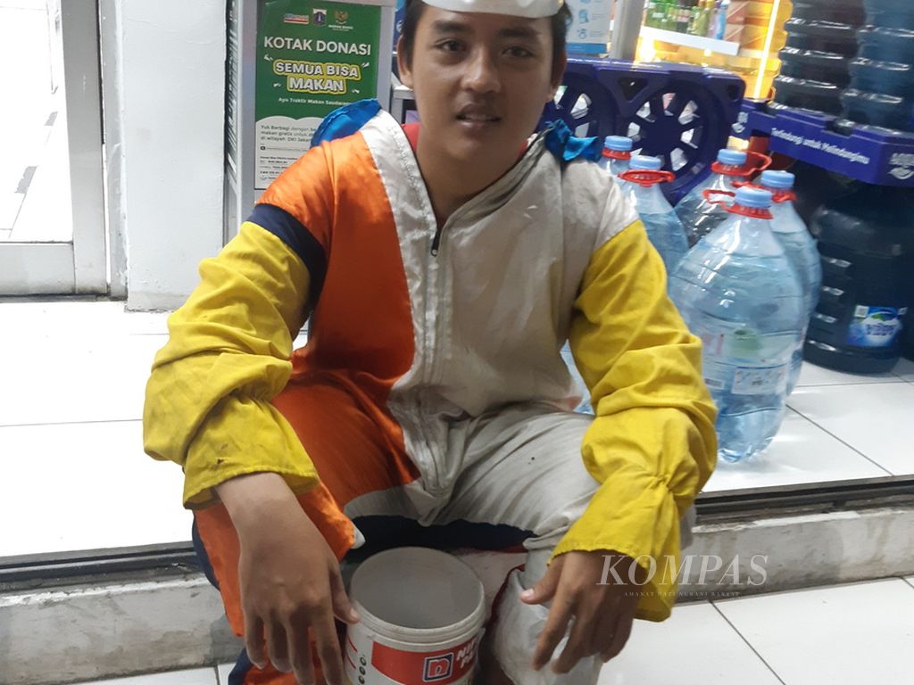Maulana (21), badut yang tengah menanti pelanggan masuk dan keluar minimarket di Simpang Rawa Belong KH Taisir, Palmerah, Jakarta Barat, Kamis (16/6/2022) malam.
