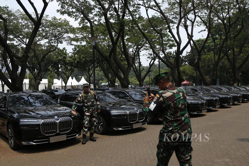 Pasukan pengaman berfoto di depan deretan mobil listrik yang terparkir di Parkir Timur, Gelora Bung Karno, Senayan, Jakarta, Senin (28/8/2023). Sebanyak 510 mobil listrik akan digunakan oleh delegasi dan panitia sepanjang rangkaian KTT Ke-43 ASEAN di Jakarta pada awal September 2023. 