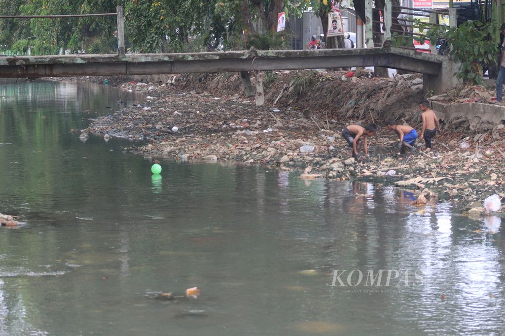 Tiga anak sedang bermain di bantaran anak Sungai Bekasi di Kota Bekasi, Jawa Barat, Selasa (19/9/2023). Aliran Sungai Bekasi sebagai air baku Perumda Tirta Patriot tercemar limbah dan mengalami kekeringan. Kondisi ini membuat kualitas air bersih di Kota Bekasi menurun.