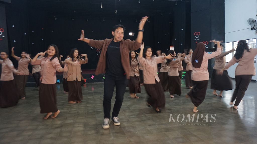 Ketua Kompetensi Keahlian Seni Tari SMK Negeri 12 Surabaya Abing Santoso dan para siswi kelas XII berlatih menari di salah satu studio di kompleks sekolah tersebut, Jumat (22/9/2023). Mereka dikenal luas sejak 2022 setelah viral di media sosial karena metode pembelajaran yang unik untuk pelestarian seni tari.