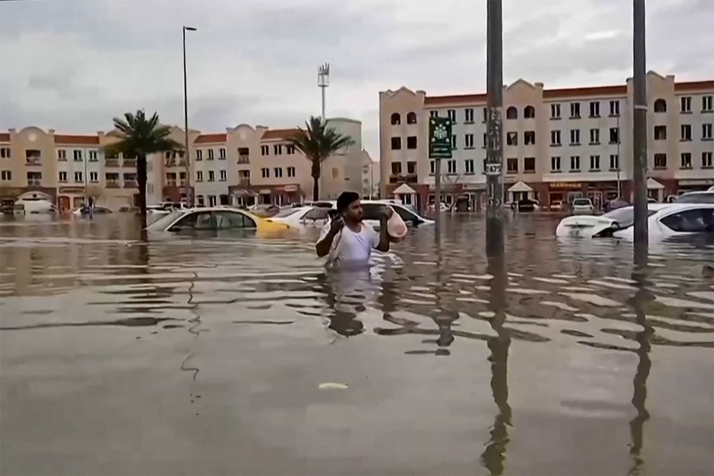 Dalam video yang diambil dari AFPTV ini, seorang pria berjalan melalui jalan yang banjir di Dubai pada 16 April 2024. 