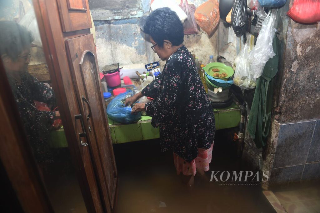 Nurfatima beraktivitas di rumahnya yang terendam banjir di Bungurasih, Kecamatan Waru, Sidoarjo, Jatim, Selasa (6/2/2024). Hujan deras sepanjang malam sehari sebelumnya membuat sejumlah daerah di Sidoarjo tergenang banjir. 