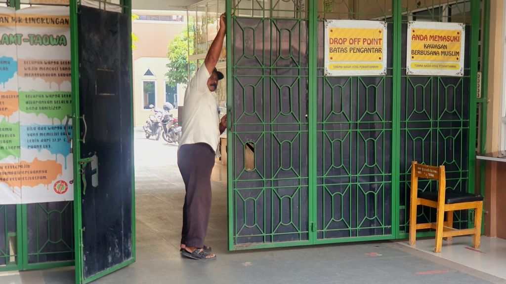 Raharjo, satpam Sekolah Menengah Pertama (SMP) At Taqwa, Benda Baru, Tangerang Selatan saat menutup pintu sekolah pada Jumat (23/6/2023). Lokasi ini menjadi awal mula penculikan N (15) siswa kelas 2 SMP oleh gurunya sendiri, Galang.