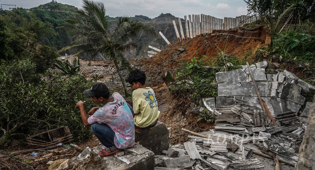 Warga yang menonton lokasi kerusakan di Kampung Ciater, Desa Cipinang, Kecamatan Rumpin, Kabupaten Bogor, Jawa Barat, akibat tanah longsor, Senin (13/9/2021). Tanah longsor yang terjadi pada Jumat (10/9/2021) akibat aktivitas penambangan batu ini berdampak pada sejumlah kerusakan, seperti rumah warga dan putusnya jalan desa. 