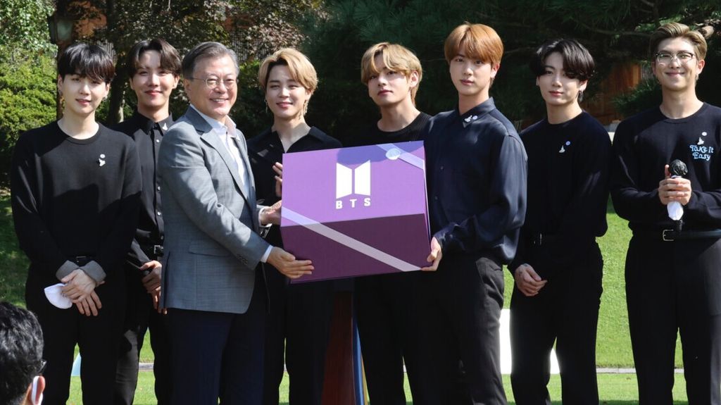 Presiden Korea Selatan Moon Jae-in (tiga dari kiri) menerima hadiah dari anggota kelompok band BTS saat Hari Anak Muda Nasional di Gedung Biru, Korea Selatan, 19 September 2020.