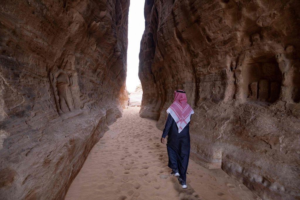 A man walking around the Ancient Nabataean tomb carved into the archaeological site of Al-Hijr (Hegra), located in the northwestern region of Al-Ula, Saudi Arabia.
