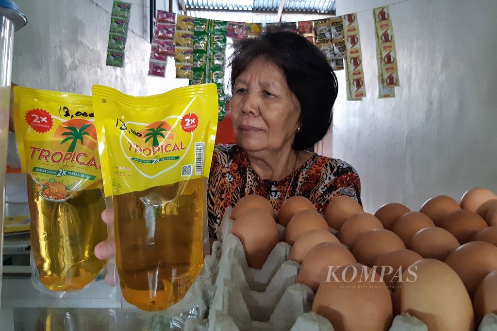 Marlia Rati (60) menunjukkan minyak goreng kemasan setengah liter yang ia jual di warungnya dengana harga Rp 13.000 di Perumahan Balikpapan Baru, Kota Balikpapan, Kalimantan Timur, Selasa (8/3/2022). Ia terpaksa menjual dengan harga tinggi karena ia membelinya Rp 11.000 per kemasan setengah liter dari agen.