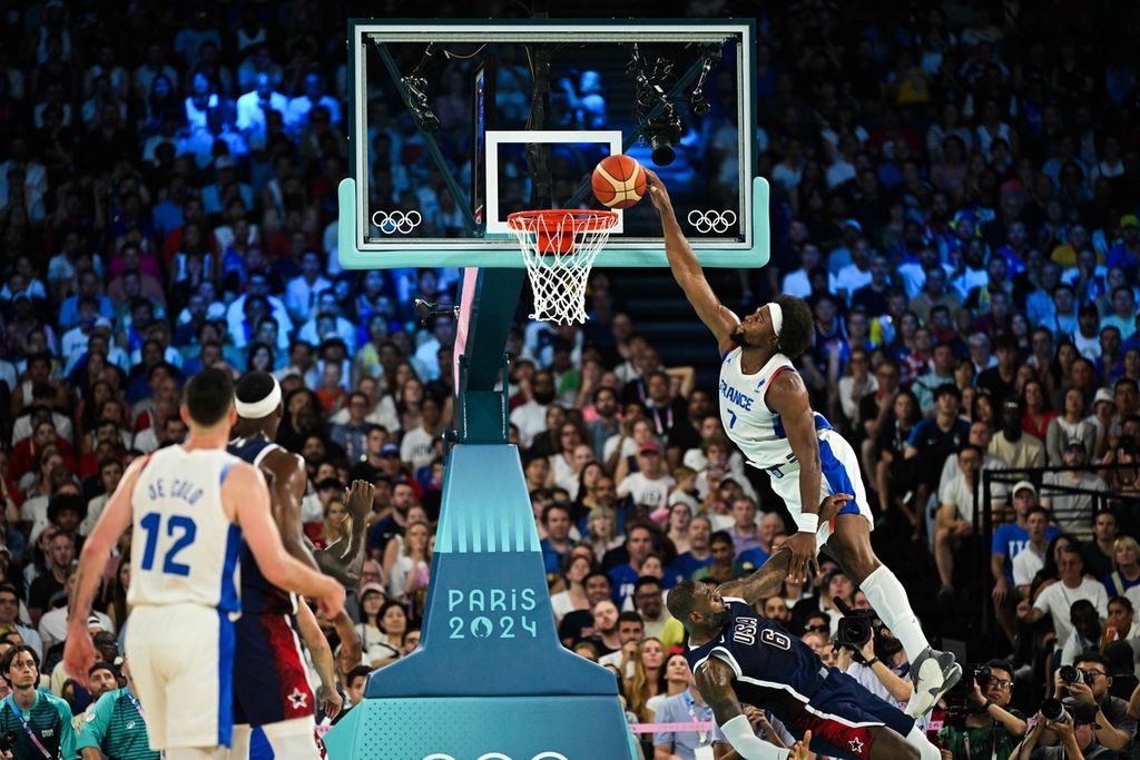 Pemain Perancis, Guerschon Yabusele, melompati pemain AS, LeBron James, untuk melakukan <i>dunk </i>pada final basket Olimpiade Paris 2024 di Bercy Arena, Paris, 10 Agustus 2024. Yabusele dikontrak klub NBA seusai laga Olimpiade.