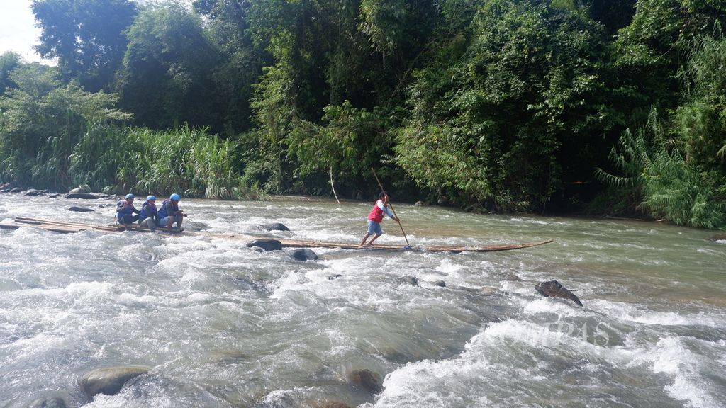 Sebuah rakit bambu membawa wisatawan menyusuri jeram Sungai Amandit di Kecamatan Loksado, Kabupaten Hulu Sungai Selatan, Kalimantan Selatan, Minggu (9/7/2023). Kegiatan<i> bamboo rafting</i> menjadi atraksi utama Festival Loksado, yang berlangsung pada 7-9 Juli 2023.