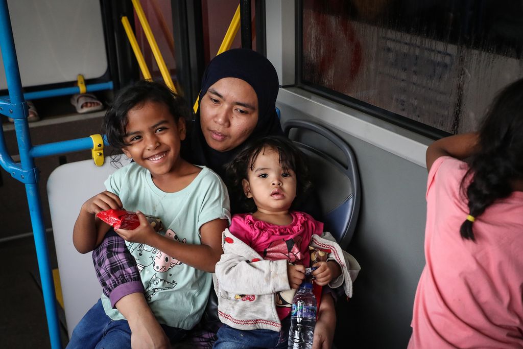 Warga Negara Indonesia (WNI) dari Sudan bergurau dengan anak-anaknya di dalam bus di Bandara Internasional Soekarno-Hatta, Tangerang, Banten, Jumat (28/4/2023). Sebanyak 385 WNI tiba di Indonesia setelah dievakuasi dari Sudan imbas konflik bersenjata yang terjadi di negara tersebut. Pemulangan ratusan WNI ini merupakan proses evakuasi tahap pertama yang diterbangkan dari Jeddah, Arab Saudi. Mereka terdiri dari 248 perempuan, 137 laki-laki, dan 43 anak-anak. ADRYAN YOGA PARAMADWYA (Z20) 28-04-2023