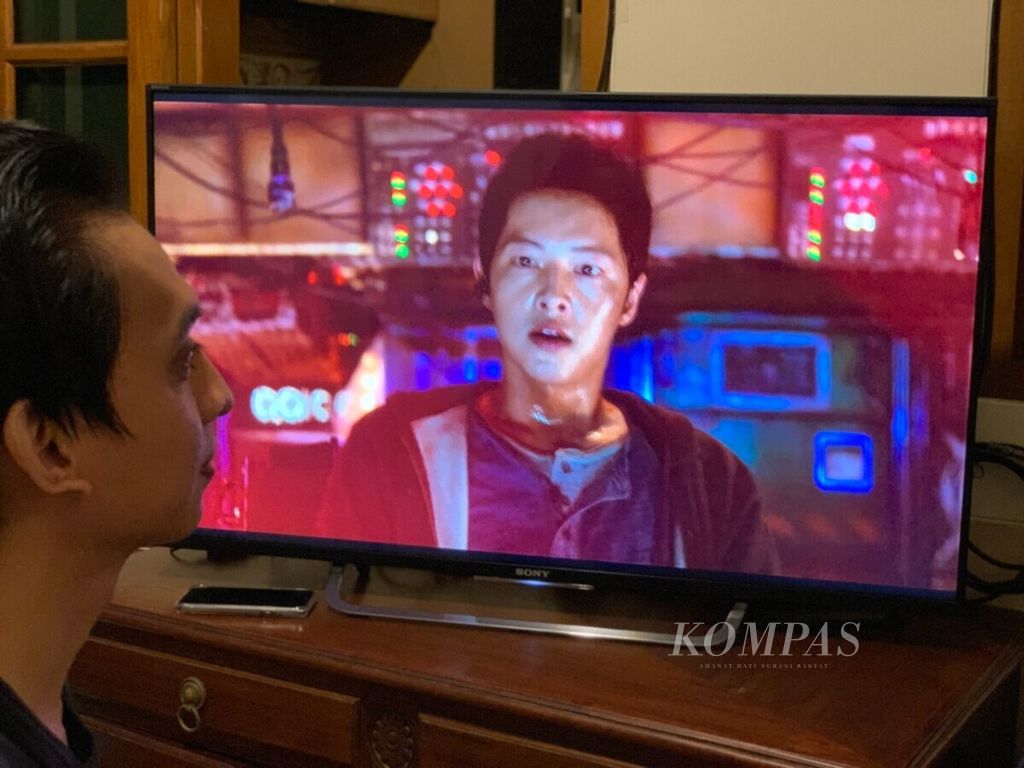 Seorang penonton di Tangerang Selatan, Banten, Sabtu (20/2/2021), tengah menyaksikan film <i>Space Sweepers</i> (2021) yang tayang di Netflix. <i>Space Sweepers</i> adalah film <i>blockbuster</i> pertama Korea Selatan tentang luar angkasa. Film ini dibintangi Song Joong-ki, Kim Tae-ri, Jin Seon-kyu, dan Yoo Hae-jin.