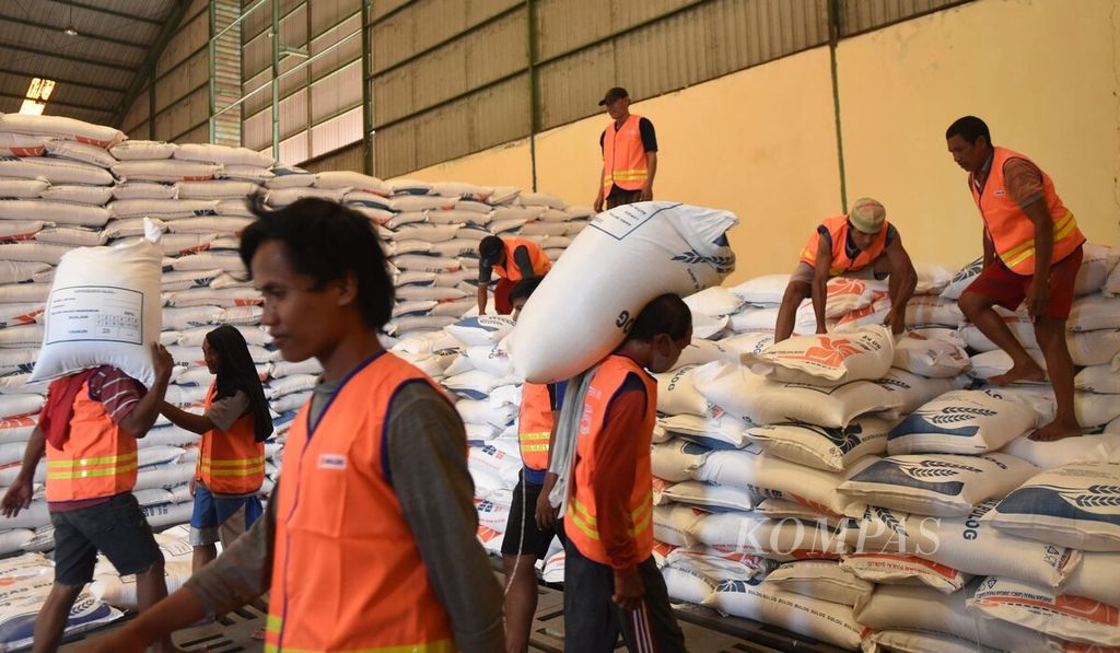 Buruh bongkar muat memindahkan karung berisi beras lokal yang baru tiba di Gudang Bulog Divre Jawa Timur di Kecamatan Buduran, Kabupaten Sidoarjo, Jawa Timur, Kamis (25/3/2021). 