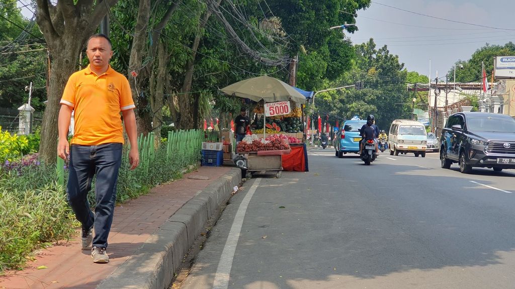 Seorang warga melintas di trotoar di Jalan Lebak Bulus Raya, Cilandak, Jakarta Selatan pada Selasa (16/5/2023). Dia harus berbagi jalan dengan pedagang yang berjualan di trotoar sehingga mengganggu pedestrian.