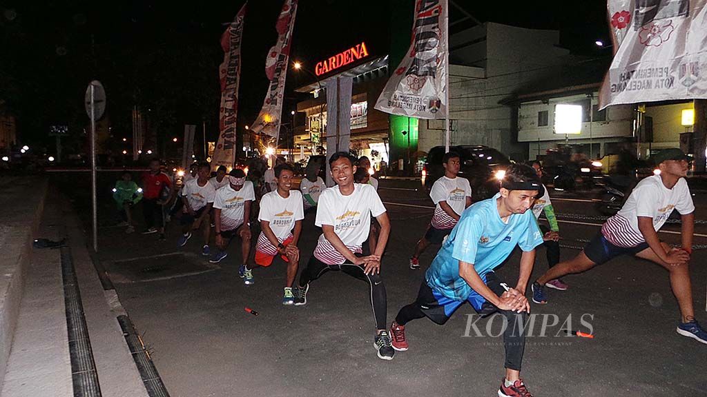 Para pelari yang tergabung dalam Magelang Runner sedang pemanasan sebelum berlatih lari di alun-alun Kota Magelang, Jumat  (20/10). 