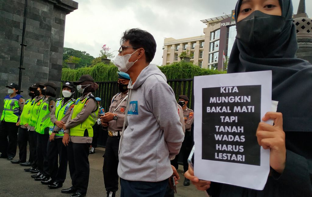  Mahasiswa membawa sebuah poster tentang kasus penangkapan dan kekerasan terhadap warga Wadas di depan Kantor Kepolisian Daerah Jawa Tengah, Kota Semarang, Kamis (10/2/2022). Aksi solidaritas ini terkait penangkapan warga Wadas yang menolak kehadiran penambangan di desa mereka.