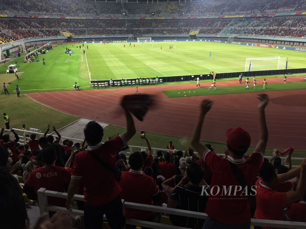 Aksi pendukung tim Indonesia U-17 dari tribune selatan Stadion Gelora Bung Tomo, Surabaya, Jawa Timur, Senin (13/11/2023), ketika tim nasional menyamakan skor 1-1 melawan Panama yang bertahan sampai laga usai.