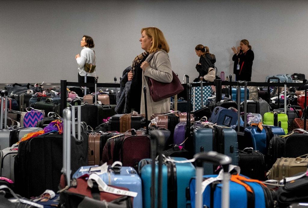 Penumpang mencari koper mereka di antara ratusan koper dari penerbangan maskapai Southwest Airlines yang dibatalkan di Bandara Internasional Nashville, Amerika Serikat, 27 Desember 2022.