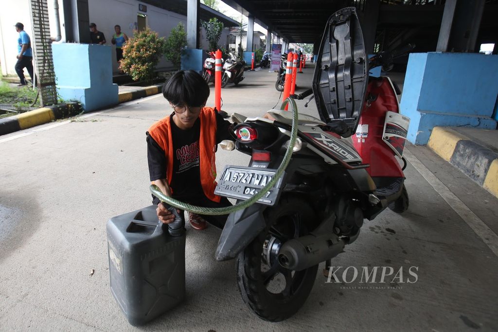 Petugas mengeluarkan BBM sepeda motor milik peserta program mudik gratis Kementerian Perhubungan, sebelum diberangkatkan ke kampung halaman dengan menggunakan truk di Terminal Pondok Cabe, Tangerang Selatan, Banten, Jumat (5/4/2024).  