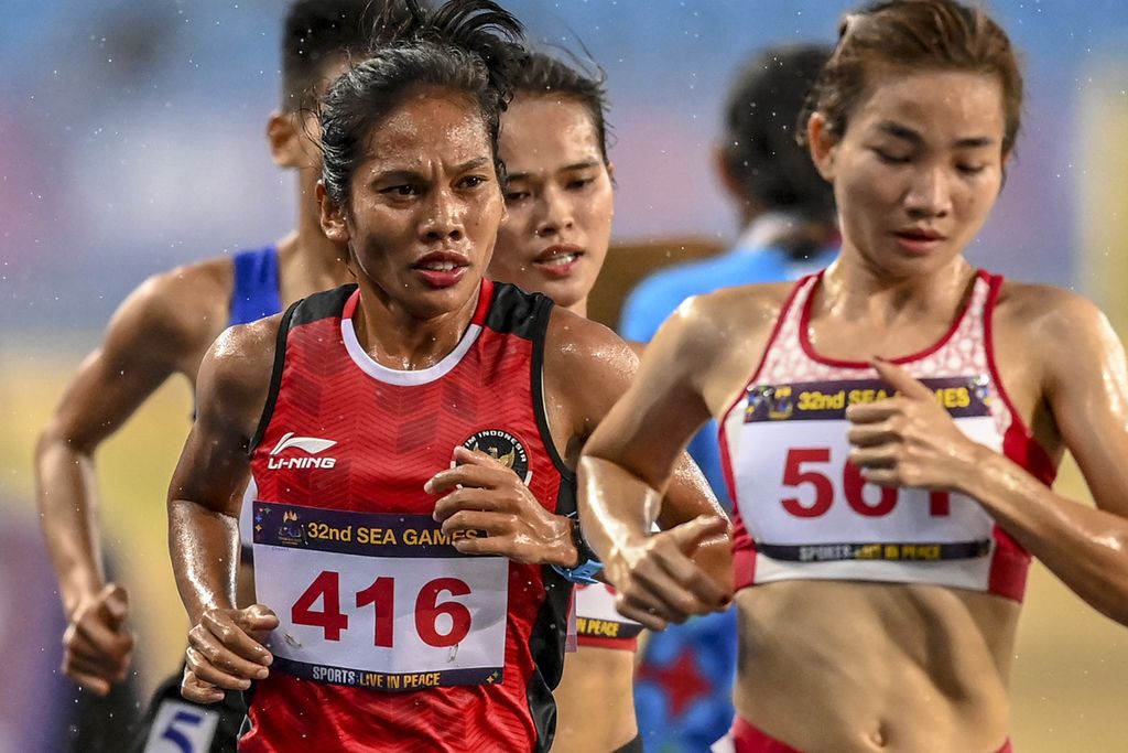 Pelari putri Indonesia, Odekta Elvina Naibaho (kiri), berusaha menyusul pelari Vietnam, Thi Oanh Nguyen (kanan), pada nomor lari 5.000 meter putri SEA Games 2023 di Phnom Penh, Kamboja, Senin (8/5/2023). Odekta meraih medali perunggu. 