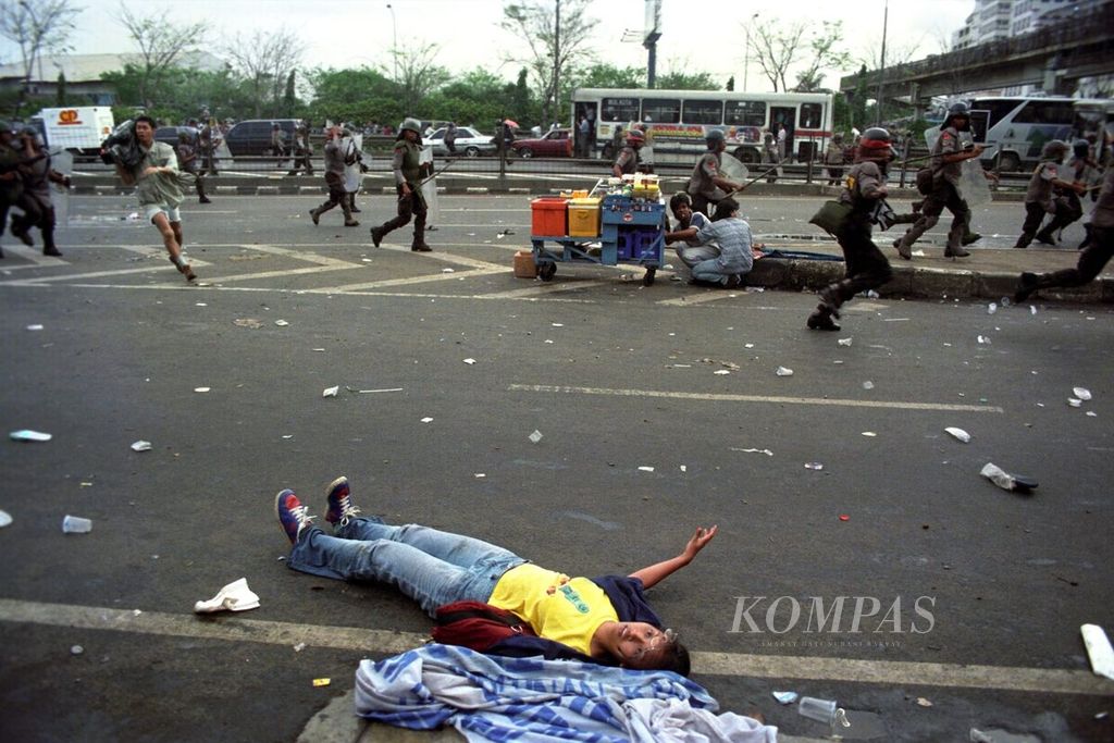 Seorang mahasiswa tergeletak di tepi jalan saat terjadi kerusuhan menyusul demonstrasi mahasiswa di depan kampus Universitas Trisakti, Jakarta, 12 Mei 1998.