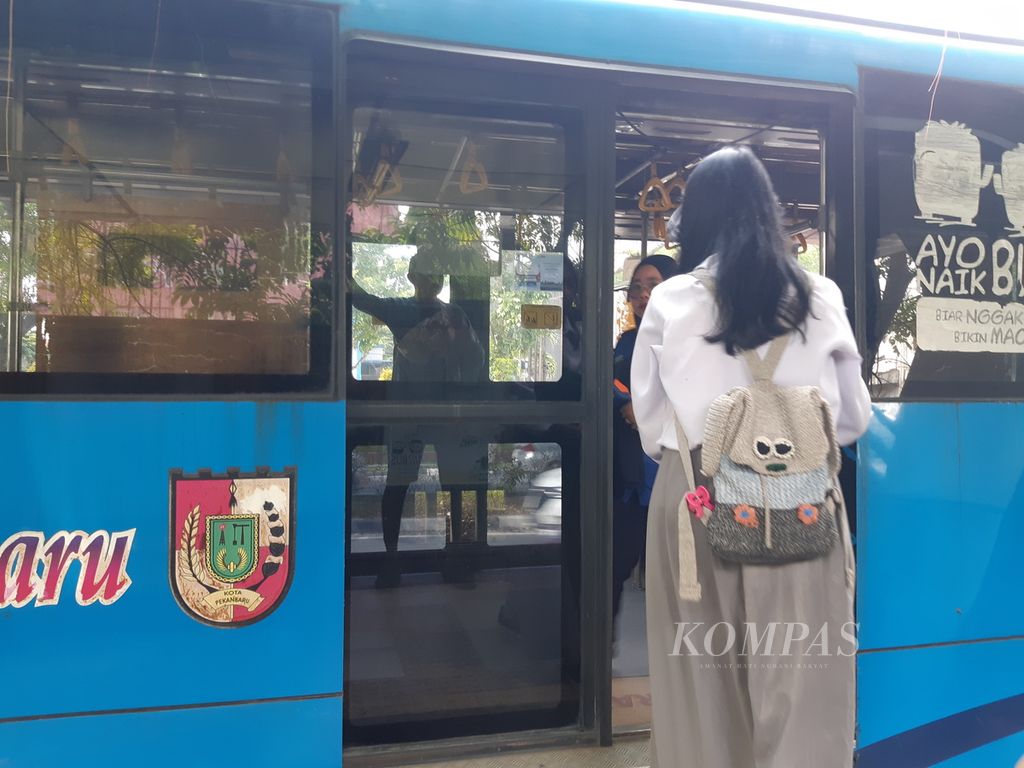 Seorang warga akan menumpangi bus Trans Pekanbaru di Kota Pekanbaru, Riau, Senin (15/7/2024). Walau mengalami sejumlah masalah, seperti kurangnya armada karena keterbatasan anggaran, bus ini masih menjadi pilihan warga Pekanbaru.