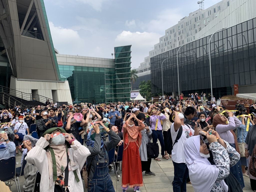 Antusias pengunjung mengikuti pengamatan gerhana matahari hibrida di Plaza Teater Jakarta Taman Ismail Marzuki, Jakarta, Kamis (20/4/2023).