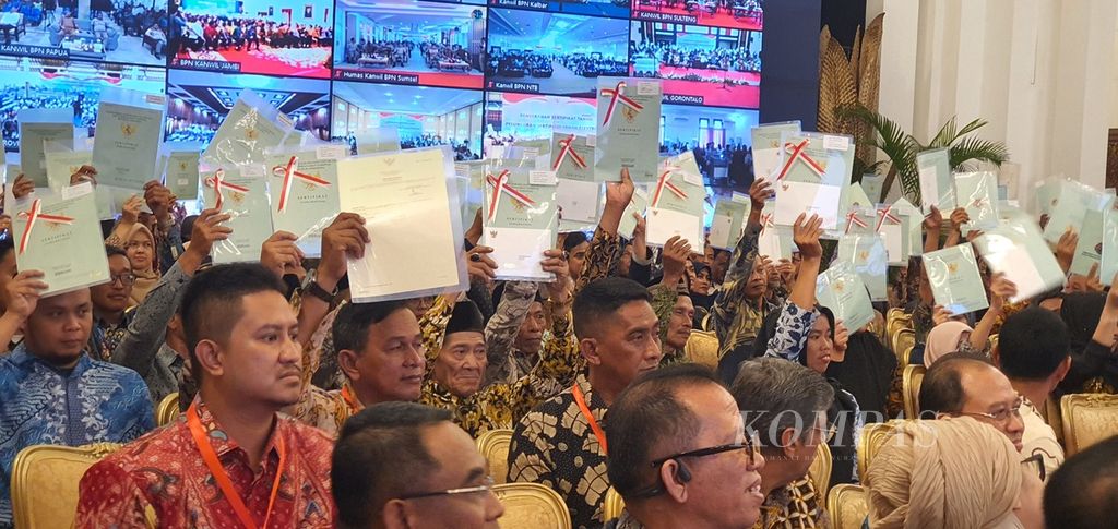 Warga menunjukkan sertifikat yang baru dibagikan. Lebih dari 2,5 juta sertifikat dibagikan dalam penyerahan sertifikat tanah dan peluncuran sertifikat tanah elektronik secara daring dan luring di Istana Negara, Jakarta, Senin (4/12/2023).