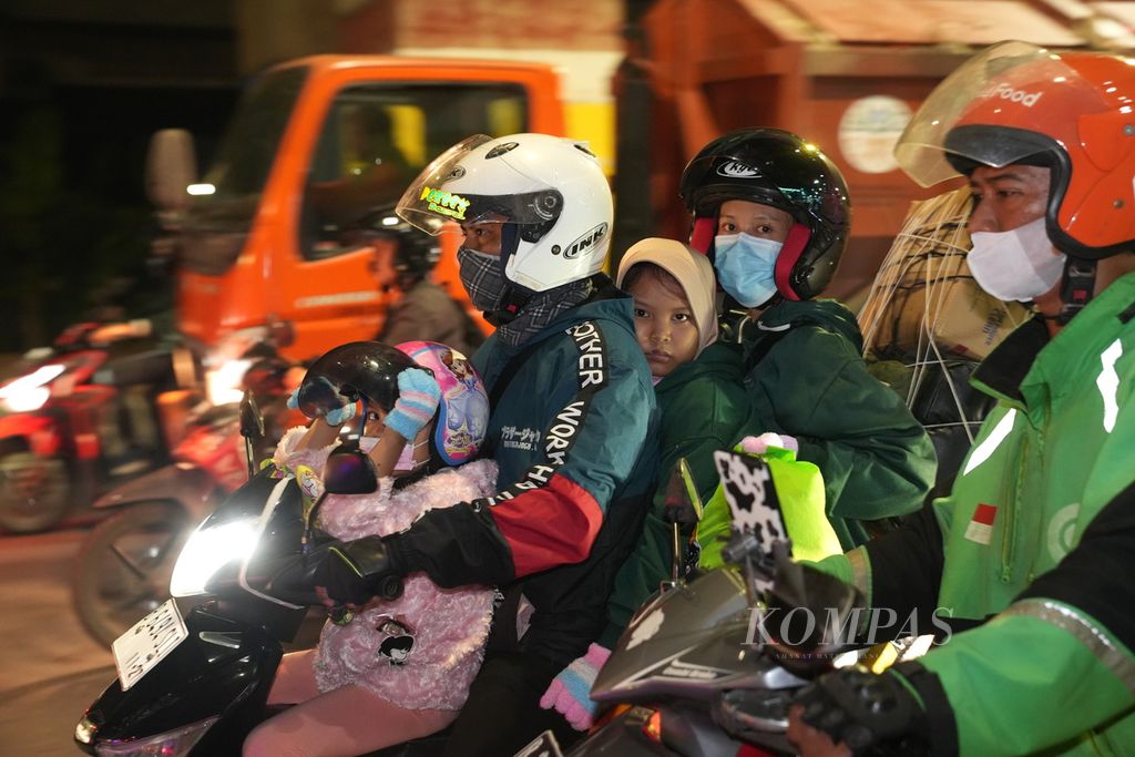 Pemudik bersepeda motor membawa dua anak melintas di Jalan Raya Kalimalang, Jakarta Timur, Jumat (5/4/2024).