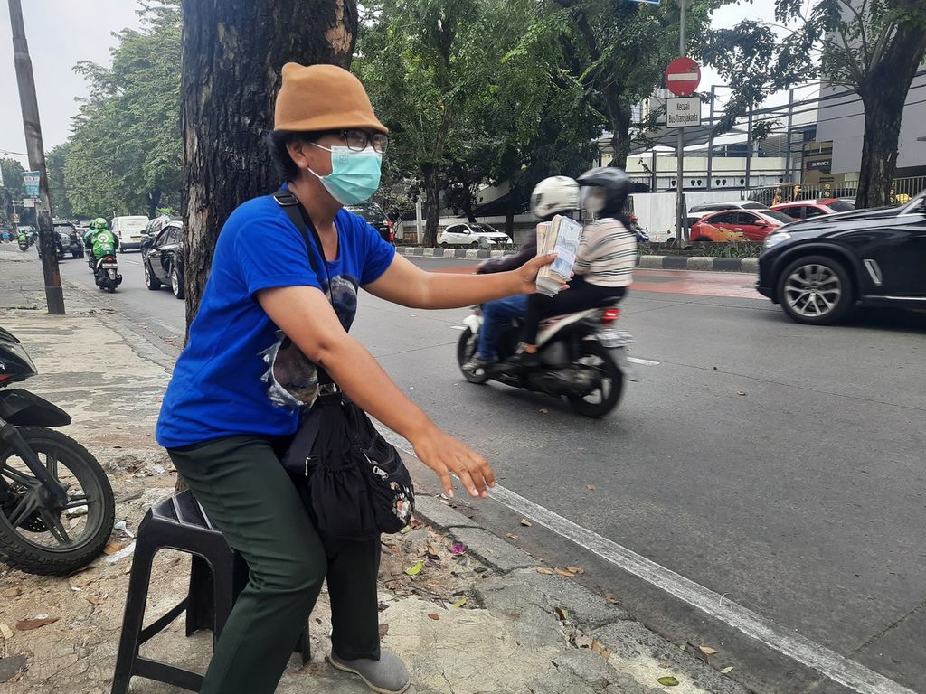 Penjual jasa tukar uang, Sriwati (42) sedang menawarkan uang-uang baru pecahan Rp 2.000 dan Rp 5.000 di Jalan Arteri Pondok Indah, Jakarta Selatan, Rabu (19/4/2023).