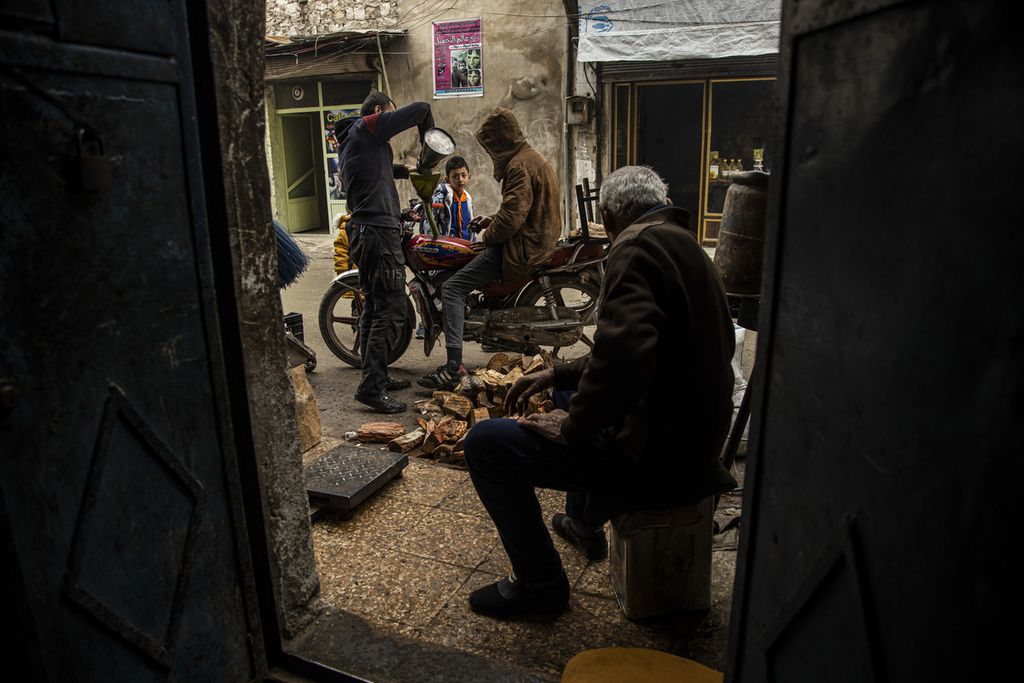 Seorang pria membeli minyak di pasar gelap di Aleppo, Suriah, 15 Desember 2022. 