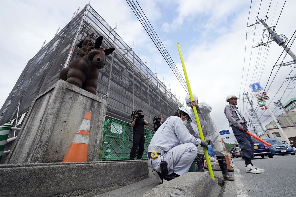 Pekerja menyiapkan barikade pembatas tempat dibangun papan baliho besar untuk menutupi pemandangan Gunung Fuji di Fujikawaguchiko, Prefektur Yamanashi, Jepang, 30 April 2024. 