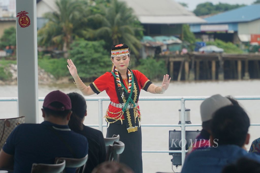Seorang perempuan menampilkan tarian Rejang Bueh dari suku Dayak Bidayuh di atas Kuching Royal Cruise yang berlayar di Sungai Sarawak, kota Kuching, Sarawak, Malaysia, Kamis (22/2/2024) sore. 