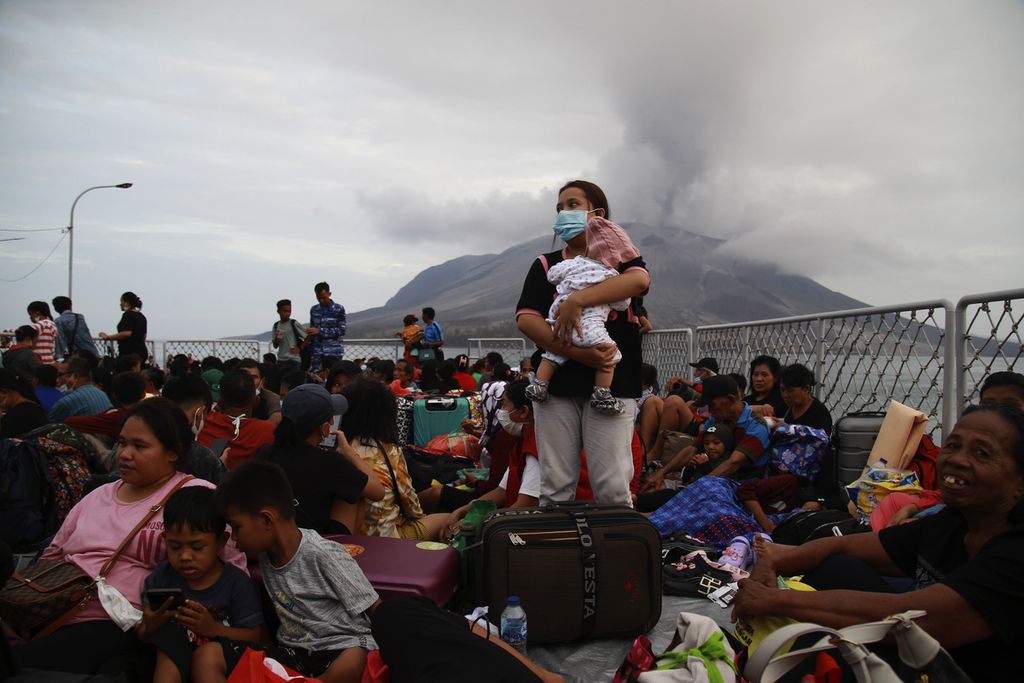 A resident carries their child on the deck of KRI Kakap-811 during evacuation at Tagulandang Port, Sitaro Islands Regency, North Sulawesi, on Wednesday (1/5/2024). The Navy's Danlantamal VIII evacuated around 330 people affected by the eruption of Mount Ruang using KRI Kakap-811 heading to Bitung Port due to the mountain's activity reaching Level IV Awas status.
