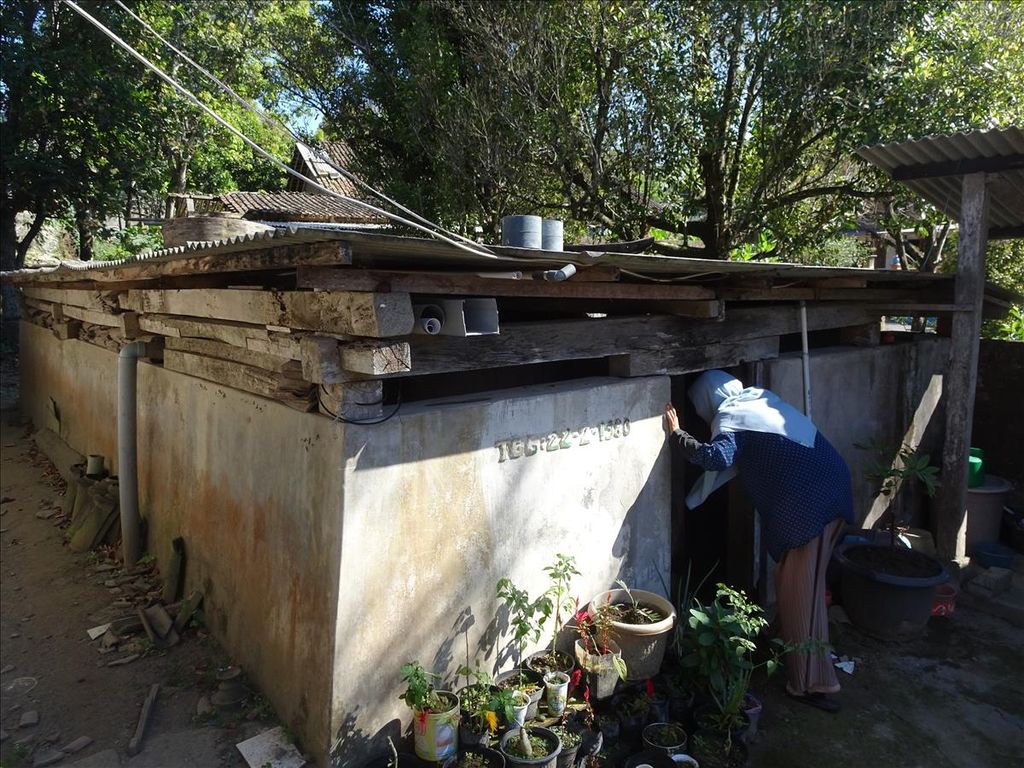 Seorang warga mengecek bak penampungan air bersih di Desa Sruni, Kecamatan Musik, Kabupaten Boyolali, Jawa Tengah, Rabu (12/6/2019). Bak itu digunakan untuk menampung air hujan ataupun air bersih yang dibeli seharga Rp 110.000 per tangki berisi 5.000 liter air.
