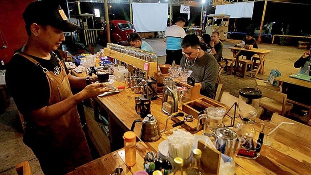 Suasana interaksi produsen dan konsumen di salah satu warung kopi yang khusus menjual kopi asli Sumatera Selatan di Palembang, Senin (16/10/2017) malam. Kopi asli Sumatera Selatan semakin diminati penikmat kopi. Hal ini tampak dari semakin banyak bermunculan warung kopi yang khusus menjual kopi asli Sumatera Selatan.