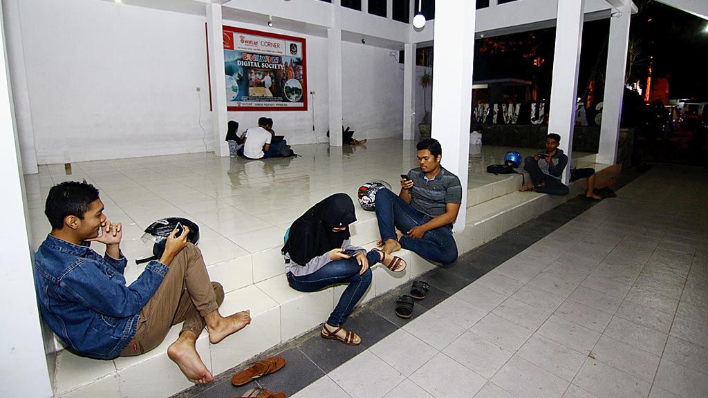 Sejumlah pemuda menggunakan fasilitas Wi-Fi gratis di Pendopo Sayu Wiwit, kompleks Taman Makam Pahlawan, Banyuwangi, Jawa Timur, Rabu (24/5). Layanan Wi-Fi gratis tersedia di sejumlah titik di pusat kota Banyuwangi dan sejumlah kantor instansi pemerintahan, seperti di kantor-kantor kecamatan. 