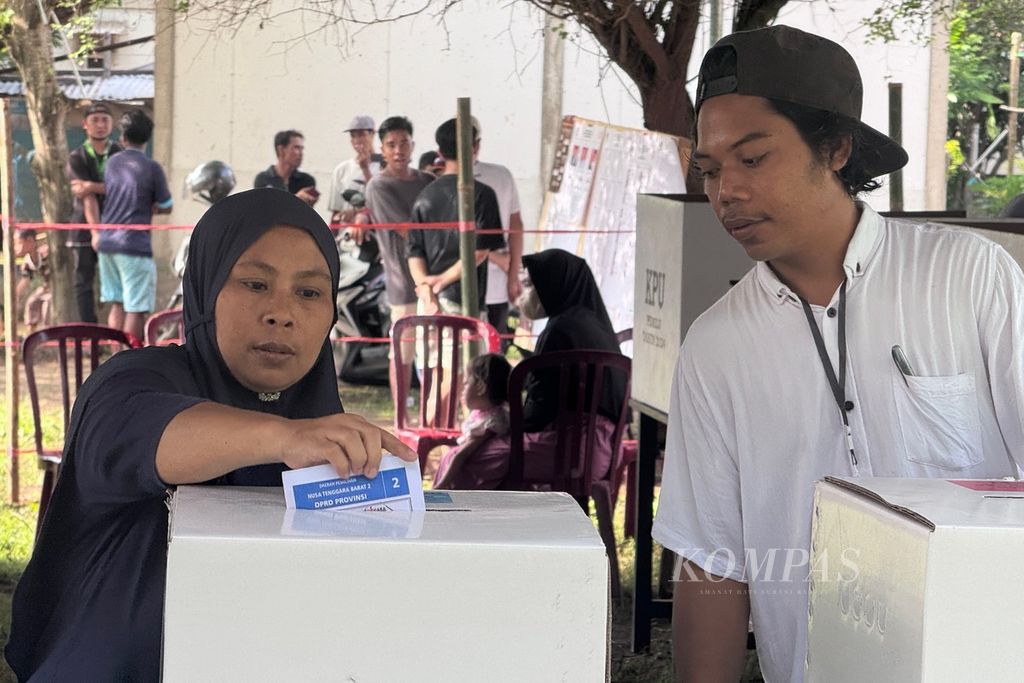 Petugas mendampingi warga saat memasukkan surat suara seusai mencoblos pada pemungutan suara ulang di Tempat Pemungutan Suara (TPS) 12 Desa Sigar Penjalin, Kecamatan Tanjung, Kabupaten Lombok Utara, Nusa Tenggara Barat, Rabu (21/2/2024).